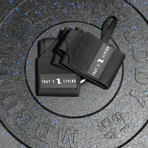 A pair of Copy of IronHide Lifting Straps labeled "THAT'S L LIVING" rests on a black, speckled 55 lb weight plate with indented lettering.