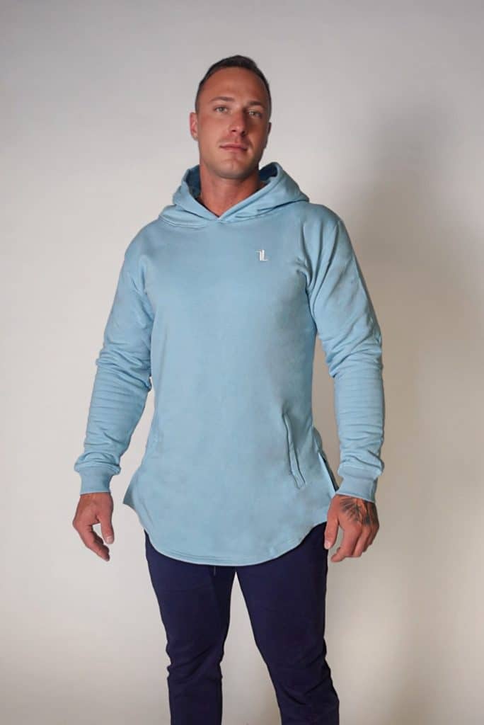 A man stands against a plain background wearing the SPEKTR Hoodie and dark blue pants, looking directly at the camera with a neutral expression.
