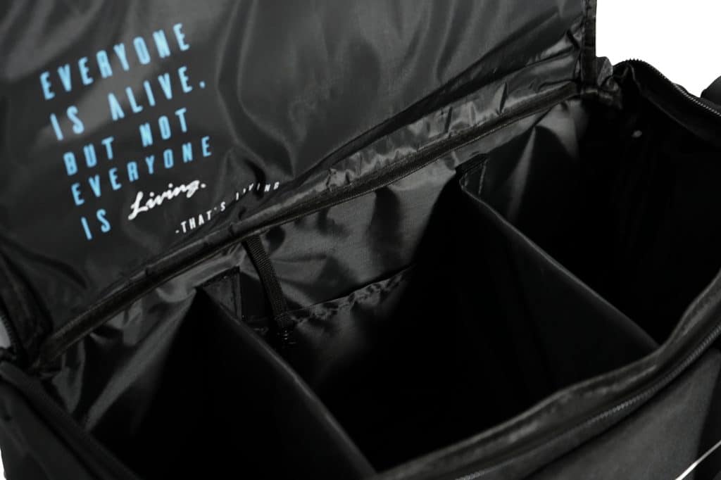 Open the TRIARC Duffle Bag featuring padded interior dividers and an inner flap with the quote in blue and white: "EVERYONE IS ALIVE. BUT NOT EVERYONE IS Living. - THAT'S THE TRUTH.