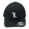 Black baseball cap with a white embroidered "TL" logo on the front and a Flexfit sticker on the brim, shown against a white background.