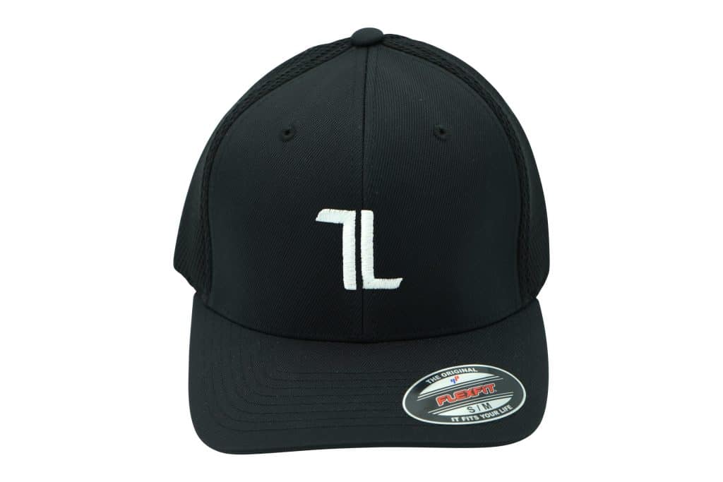 Black baseball cap with a white embroidered "TL" logo on the front and a Flexfit sticker on the brim, shown against a white background.