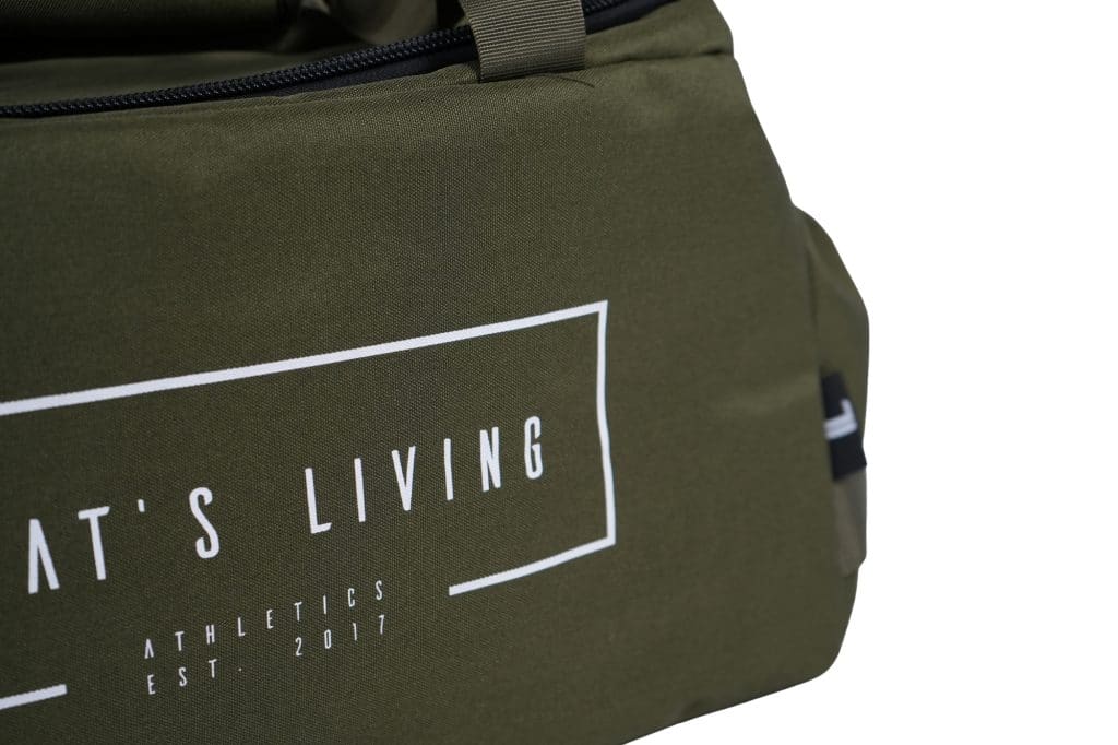 Close-up of the olive green TRIARC Duffle Bag featuring white text, including “ATHLETICS EST. 2017” and a partial phrase ending in “T’S LIVING.” The bag includes a handle and side pocket.