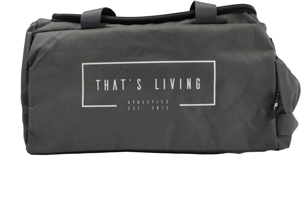 A dark gray duffel bag with black handles. The front features white text that reads "THAT'S LIVING ATHLETICS EST. 2017" inside a rectangular outline.