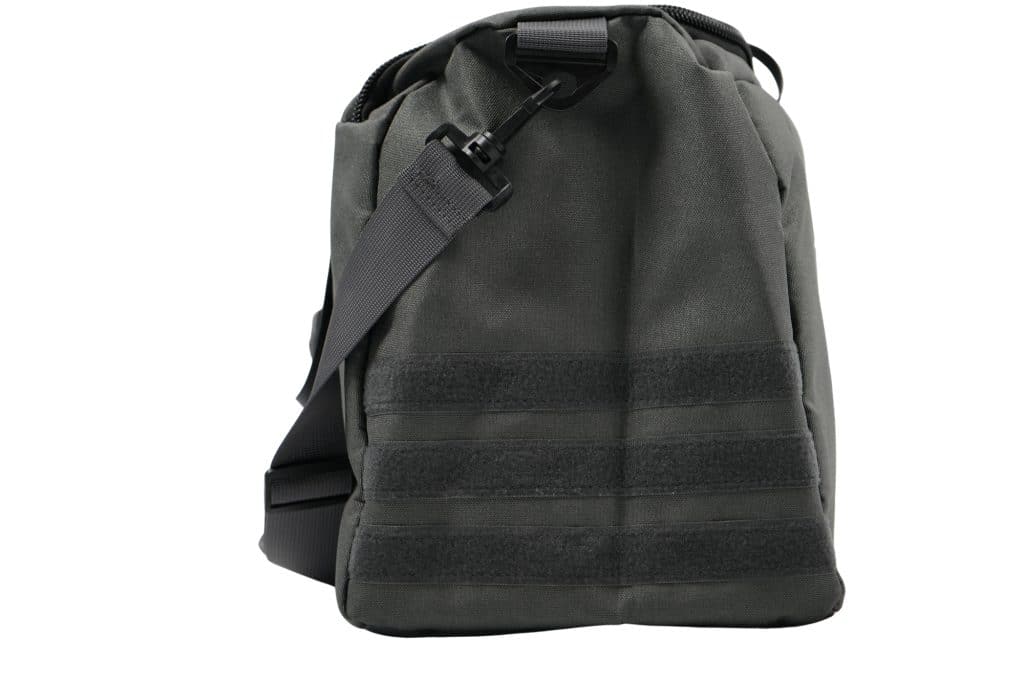 The TRIARC Duffle Bag is a dark gray tactical shoulder bag featuring a black adjustable strap, black buckle clip, and horizontal Velcro strips on the front, displayed against a white background.