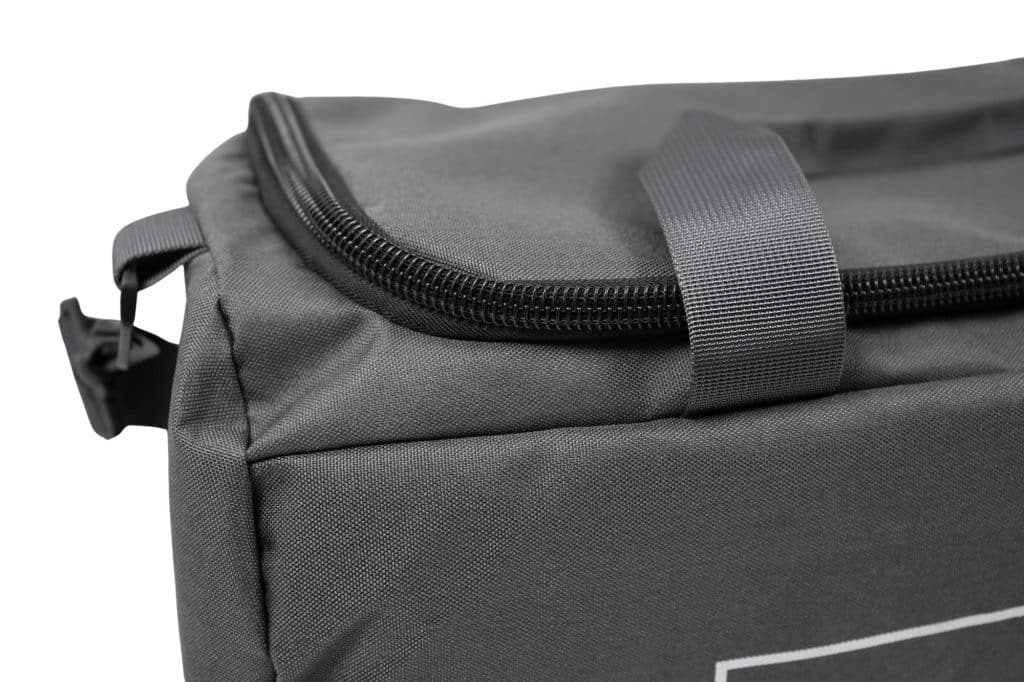 Close-up of the top corner of the TRIARC Duffle Bag, featuring gray fabric, a zipper, and a sturdy gray handle against a white background.