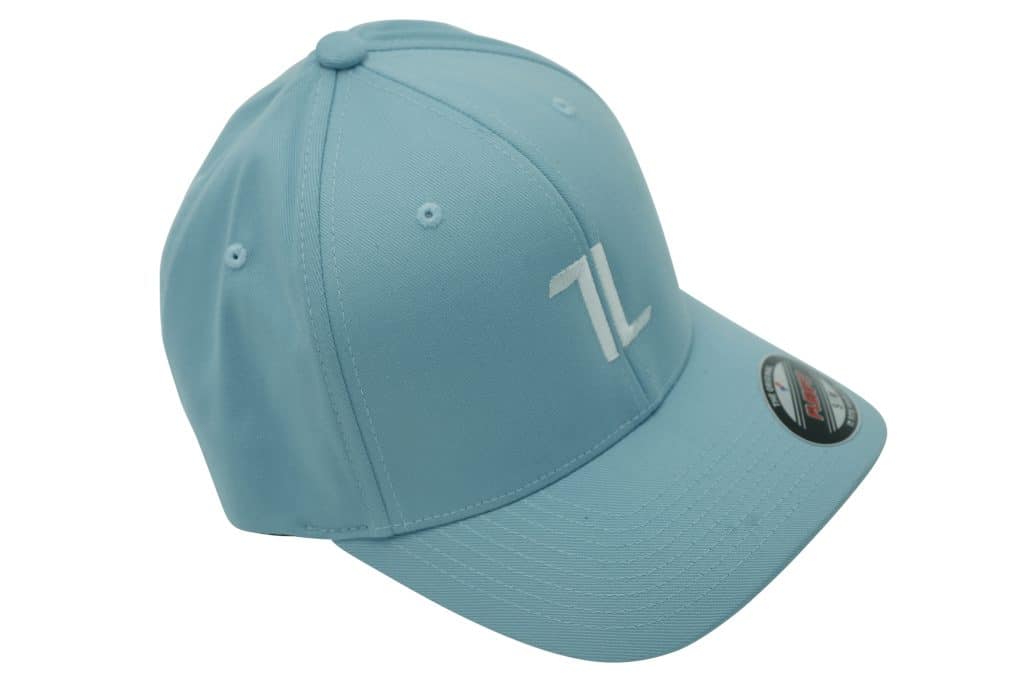 The Original Ball Cap features a light blue color with white stitching and a white "TL" logo on the front. It has a curved brim and includes a black and red sticker on the bill.