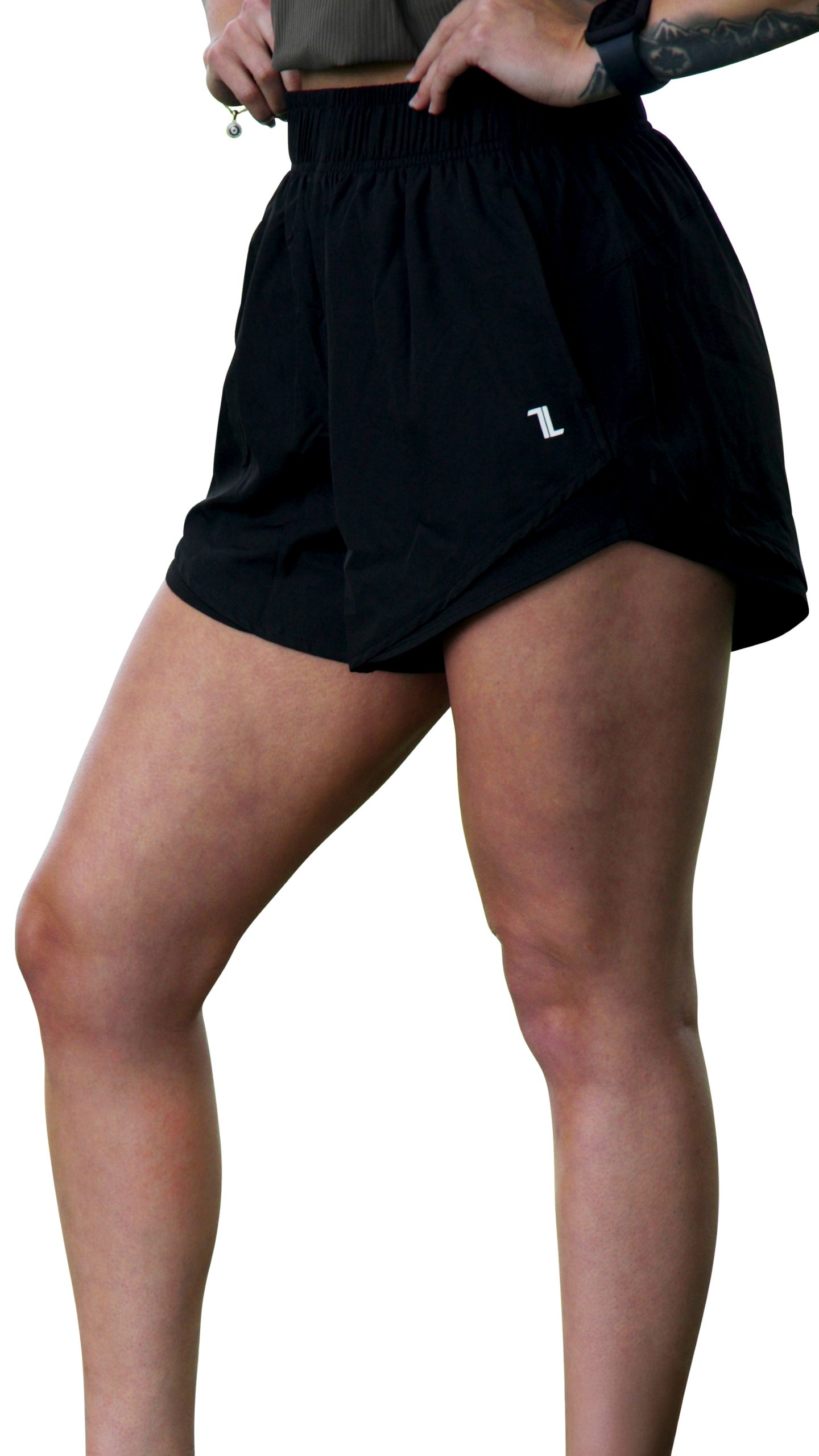A person stands with one leg slightly forward, wearing GLYDE Shorts in black with a small white logo on the left side. The focus is on the lower torso and legs, paired with a gray top.