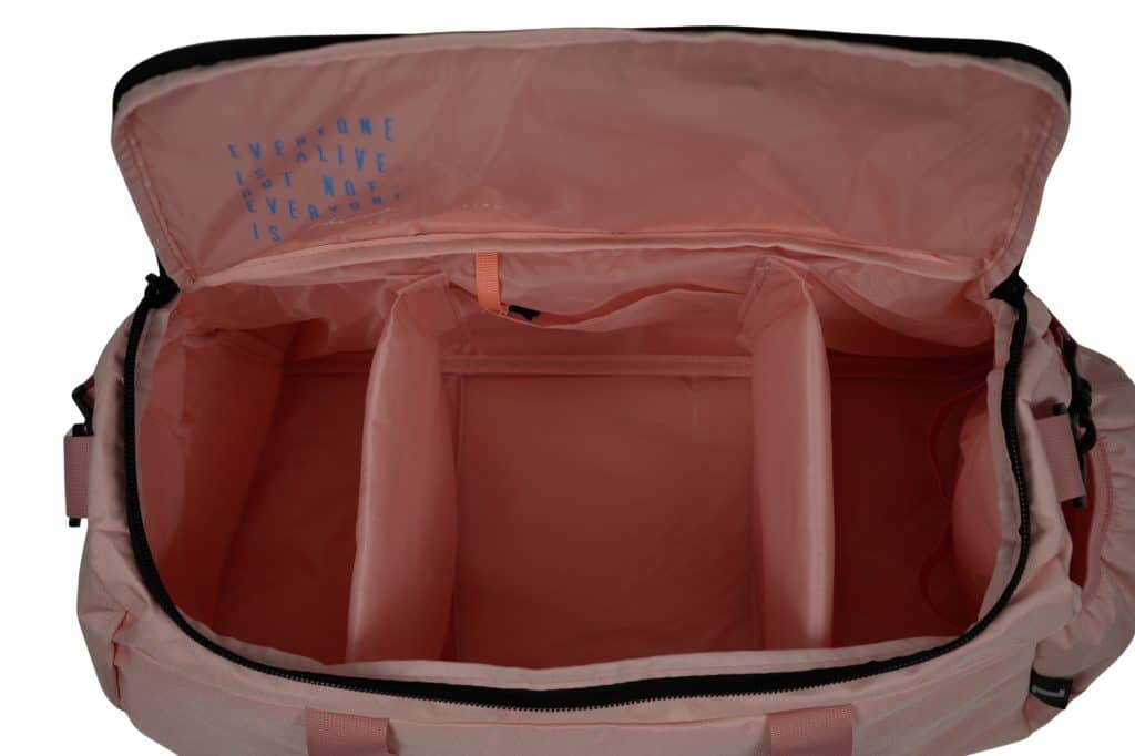 The TRIARC Duffle Bag is an open pink duffel featuring three spacious interior compartments and an unzipped lid. Inside, the lid displays blue text: "EVERYONE ISN'T LIVE NOT EVERYONE ISN'T.