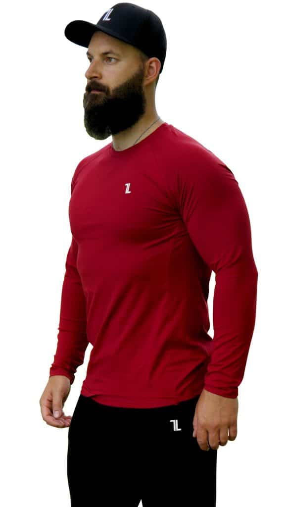 A man with a full beard wears a black cap, a fitted long-sleeve red shirt, and black pants, all branded with a small white "ZL" logo, standing against a white background.